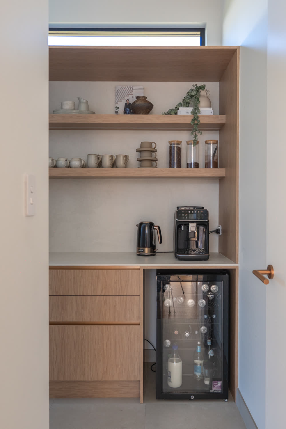 Coffee station at Glenorie — timber joinery pocket with espresso machine, kettle, open shelves and an integrated drinks fridge